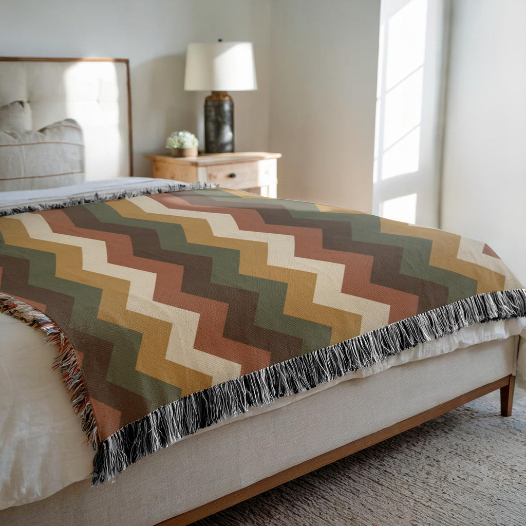 Earth-tone zigzag woven blanket design featuring rust, olive green, golden ochre, chocolate brown and cream chevron stripes.